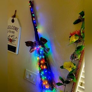 Straw type broom with l color lights and ribbon and pumpkin.